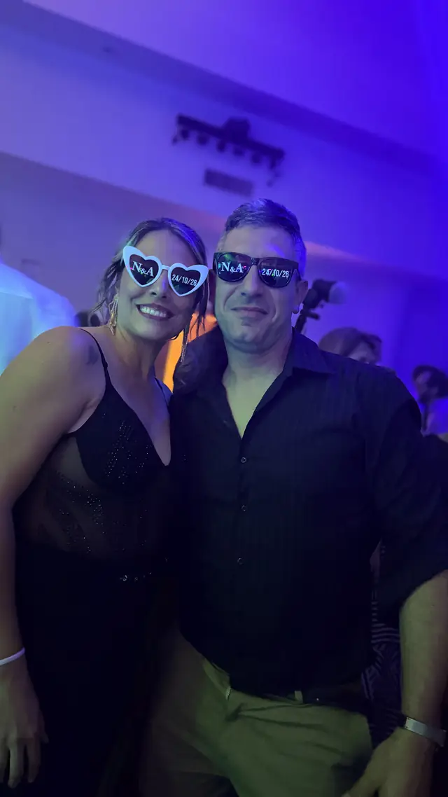 Pareja de invitados con anteojos de la boda, bajo luces azules