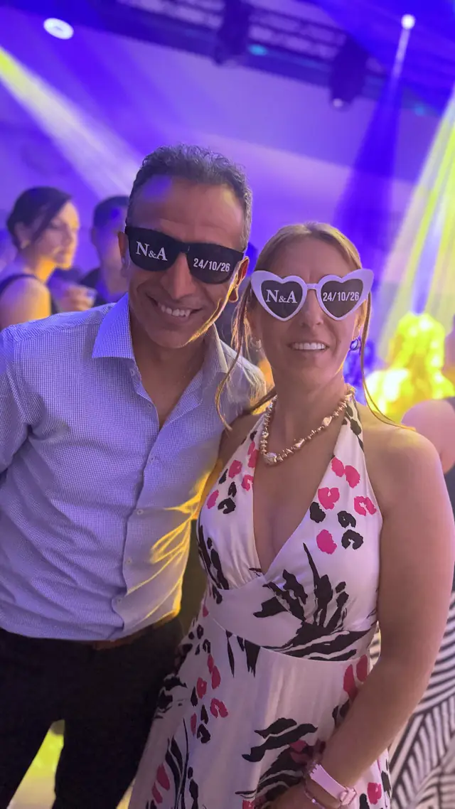 Pareja de invitados sonriendo con anteojos