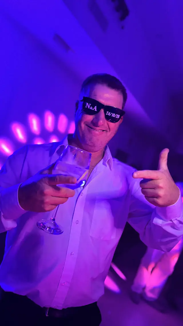 Invitado brindando bajo luces violetas