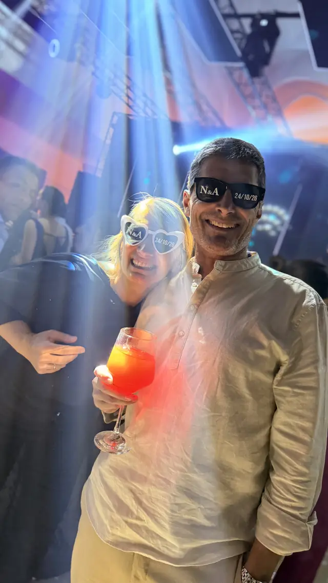 Pareja de invitados atravesada por haces de luz